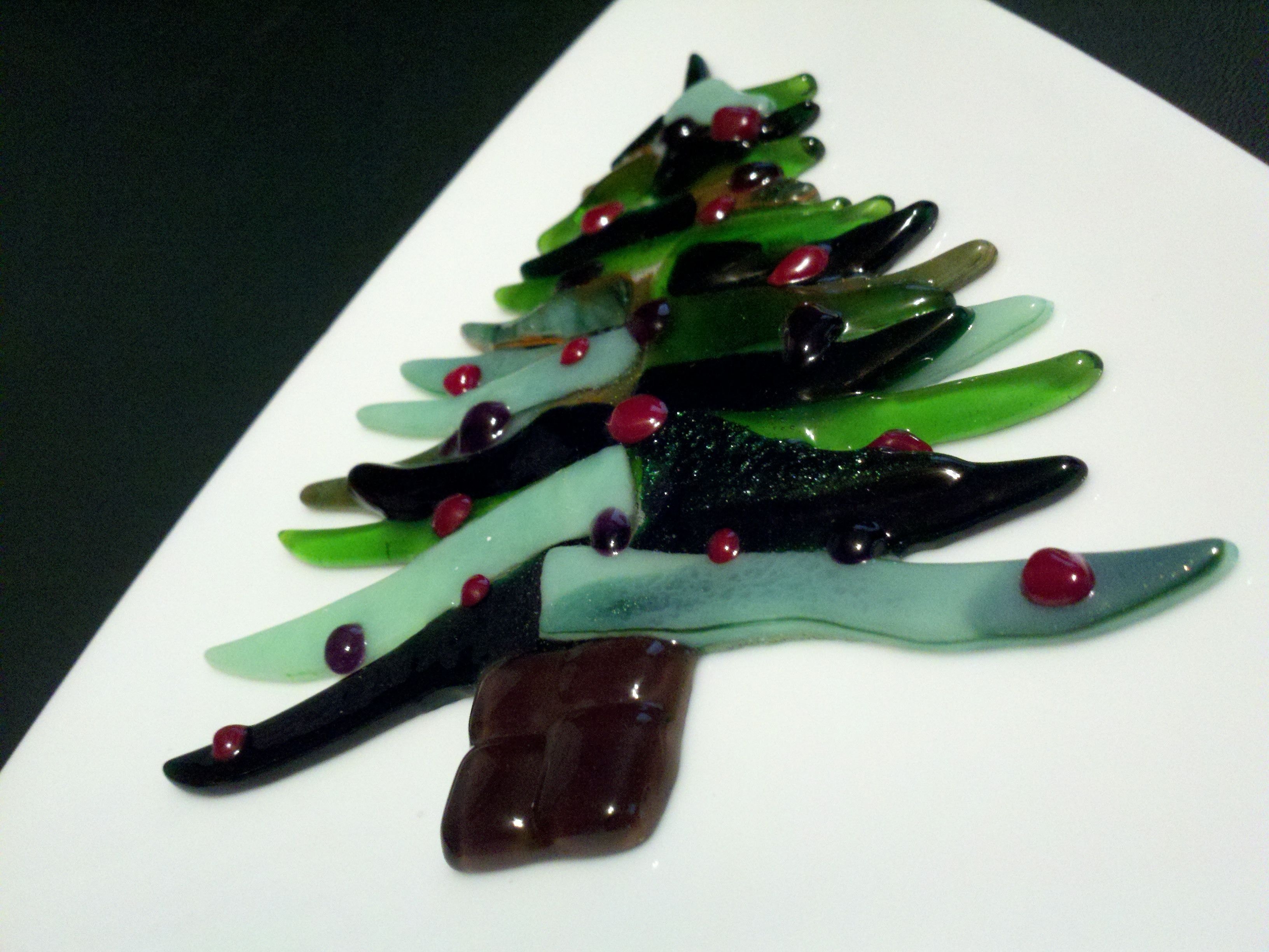 Fused glass Christmas tree with layered green and black glass branches, red berry accents