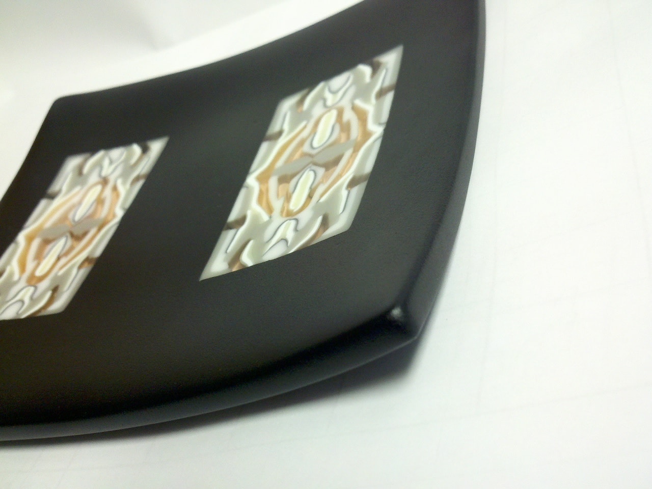 Pattern Bar - Oblique view of a black fused glass sushi plate. This piece was accidently dropped and shattered. Paul Tarlow used his amazing skills and put it back together. This is the after photo!