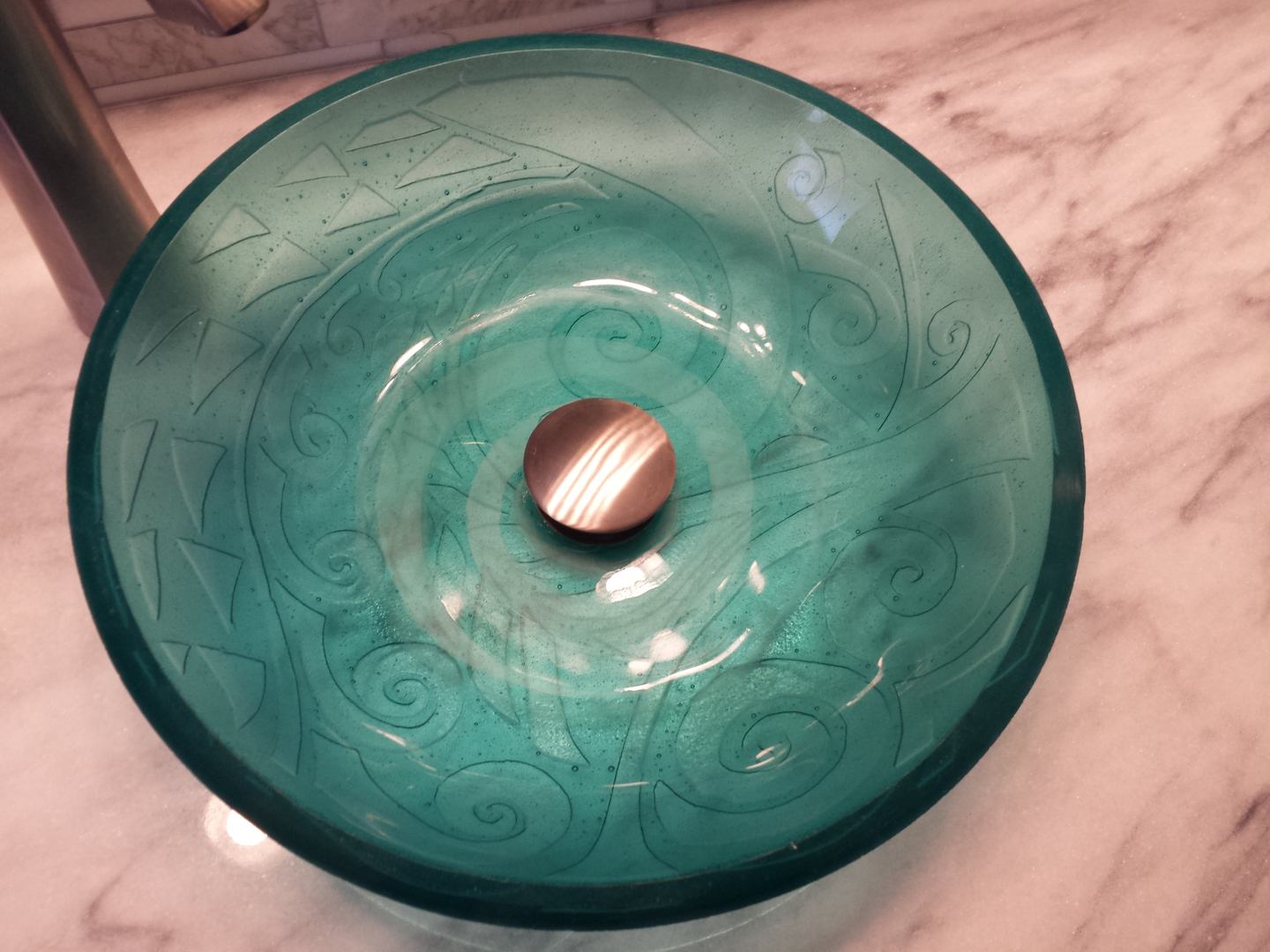 Sink created with transparent glass, kiln carved on the back for texture and sandblasted on the front to emphasize the center. We used this sink in our home.